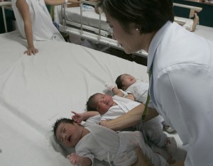 A doctor checks on three babies born at the Dr. Jose Fabella Memorial Hospital just after midnight Wednesday. The baby born at 12:01 a.m. was named Roselle. PHOTO BY RENE H. DILAN