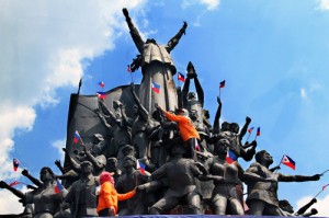 Workers install small flags at the People Power monument on EDSA on Thursday as the country prepares to mark the anniversary of the peaceful uprising in 1986. PHOTO BY MIKE DE JUAN