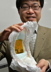 Japan’s University of Tokyo Prof. Takao Someya holding a nappy containing the world’s first flexible wireless organic sensor system at his laboratory in Tokyo on Sunday. AFP PHOTO