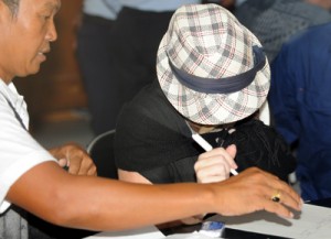 Australian drug trafficker Schapelle Corby (right) signs a form at a correction bureau in Denpasar on Indonesia’s resort island of Bali on Monday. AFP PHOTO