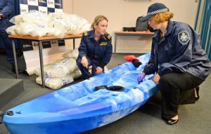 A Customs officer (left) and police inspect one of the 27 kayaks seized after Australian authorities found Aus$180 million (US$162 million) of methamphetamine stashed in a consignment of kayaks from China, in Sydney on Wednesday. AFP PHOTO