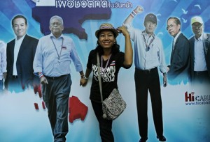 A Thai anti-government protester (center) poses for a photo in front of a billboard carrying a picture of leader Suthep Thaugsuban (second from left) at a protest site in downtown Bangkok on Tuesday. AFP PHOTO