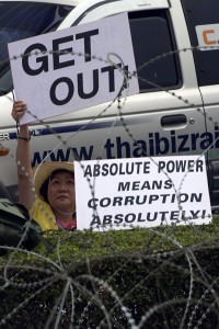 A Thai anti-government protester holds a placard behind barbed wire outside the government’s temporary office in the permanent secretary for defense suburb of Bangkok on Wednesday. AFP PHOTO