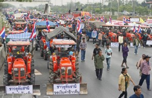 Rice farmers wait by farm trucks and tractors on a highway road in Ayutthaya province before they head to protest at Suvarnabhumi airport on Friday. AFP PHOTO