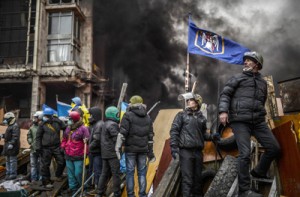 Protesters stand on barricades during clashes with police on Thursday in Kiev. AFP PHOTO