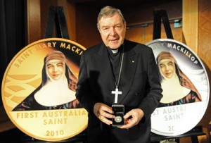 Cardinal George Pell, Catholic Archbishop of Sydney, holding a coin commemorating the canonisation of Mary MacKillop in Sydney on September 30, 2010.  AFP PHOTO 