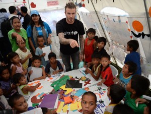 Football superstar David Beckham (center) interacts with children-survivors of Super Typhoon Yolanda during a visit to a tent city in Tacloban City, Leyte on Thursday. AFP PHOTO