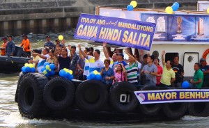 Mandaluyong City Mayor Benhur Abalos (center) and other local officials of the city wave to a crowd on Saturday during a fluvial parade along a stretch of the Madaluyong river in line with the city’s 