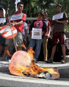 Members of militant groups burn an effigy of President Benigno Aquino 3rd after they stormed the head offices of the Manila Electric Co. (Meralco) in Ortigas Avenue, Pasig City. The groups said the government should also be held responsible for the overcharging of Meralco. Photo By Mike De Juan