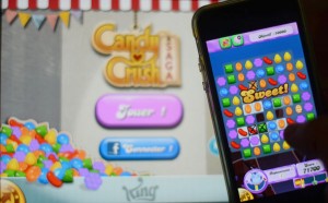 In this file picture taken on January 25, 2014 a man plays at Candy Crush Saga on his Iphone in Rome. Candy Crush is one of the top online games developped by King.com. With three young children and a full-time job, Emma Martini has little time for computer games. But every night she sits quietly at the end of her son’s bed to reassure him while he falls asleep -- and plays Candy Crush. AFP PHOTO