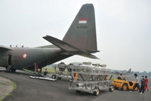 Officials load equipment as part of preparations for “cloud-seeding,” chemically induce rain, above Riau province at the air force base in Jakarta. AFP PHOTO