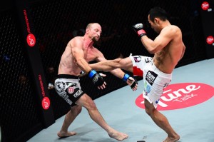 Nobutatsu Suzuki (right) delivers a front kick on Brock Larson’s midsection. photo courtesy of ONE FC