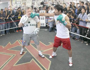 Manny Pacquiao throws a playful jab against trainer Freddie Roach. AFP FILE PHOTO