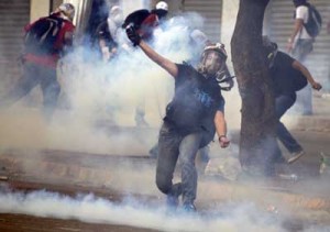 Opposition activists return tear gas to riot police during a protest against the government of Venezuelan President Nicolas Maduro in Caracas on Sunday (Monday in Manila). AFP PHOTO