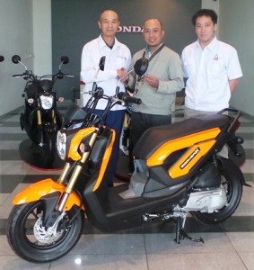 Marlon Luciano (center), a winner in one of Honda’s anniversary fest contests, poses with Honda officers and the Zoomer X.