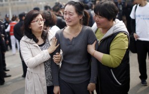 A distraught relative (center) of passengers on the missing Malaysia Airlines flight MH370 participates in a protest outside the Malaysian embassy in Beijing on Tuesday. AFP PHOTO