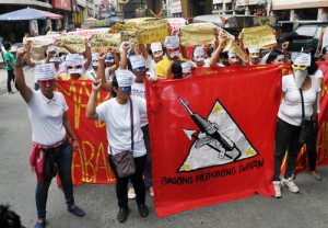 Members of the Malayang Kilusan ng Bagong Kababaihan (Makibaka), a member organization of the National Democratic Front, stage a lightning rally on Rizal Avenue in Manila on Tuesday. The group denounced the arrest of CPP-NPA leaders Benito and Wilma Tiamzon. PHOTO BY EDWIN MULI