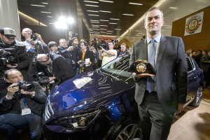 Peugeot head Maxime Picat poses next to a Peugeot 308 after the model took the Car of the Year 2014 title at the Geneva International Motor Show. AFP PHOTO