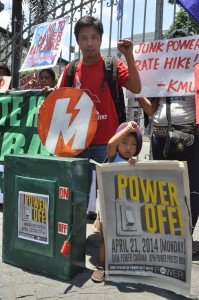 A man and his son join members of consumer group Power! who staged a rally in front of the Supreme Court building in Manila on Monday. The group asked the High Court to permanently disallow the Manila Electric Company (Meralco) from implementing the P4.15 power rate hike. PHOTO BY EDWIN MULI 