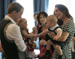 Catherine (R), the Duchess of Cambridge, holding her son, Britain's Prince George, during a visit to the Plunket nurse and parents group at Government House in Wellington.  Plunket is a national not-for-profit organization that provides care for children and families in New Zealand. AFP Photo