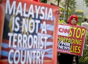 Malaysian activists hold banners during a protest accusing US news channels of unprofessional reporting on missing Malaysia Airlines flight MH370, outside the US Embassy in Kuala Lumpur on Thursday. AFP PHOTO