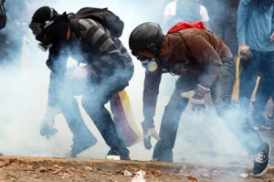 Opposition students protesting against the government of Venezuelan President Nicolas Maduro move through a cloud of tear gas at the Venezuelan Central University (UCV) campus in Caracas, on April 3, 2014. The Roman Catholic Church in Venezuela accused the leftist administration of President Maduro on Wednesday of seeking to impose a “totalitarian government” and blaming it for protests shaking the country. AFP PHOTO