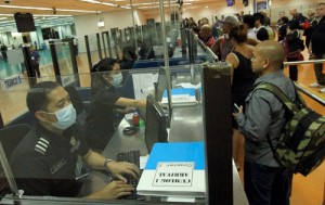 Workers at the Ninoy Aquino International Airport wear masks as they process arriving passengers as a precaution against the MERS virus. PHOTO BY BENJIE L. VERGARA