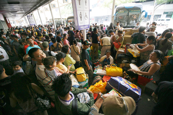 Commuters pack a bus terminal in Cubao, Quezon City on Tuesday. Thousands of Metro Manila residents usually trek to the provinces, either to relax in beaches or resorts or spend a quiet time in their hometowns during the Holy Week. PHOTO BY MIGUEL DE GUZMAN