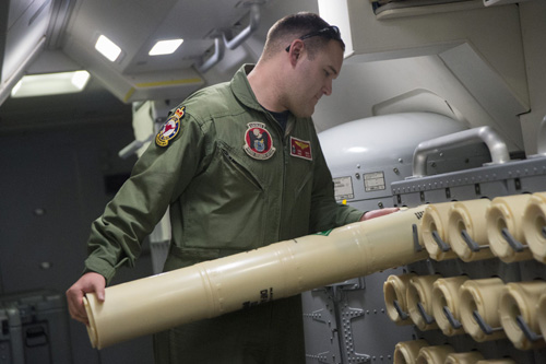 This US Navy handout photo released April 11, 2014 shows Naval Aircrewman (Operator) 2nd Class Karl Shinn, assigned to Patrol Squadron (VP) 16, as he unloads a Sonobuoy from the rack onboard a P-8A Poseidon April 10, 2014 to prepare it for use during a search mission to locate Malaysia Airlines flight MH370.