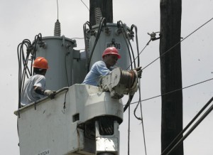 Workers check a power line in Baseco, Manila on Saturday, a day after several areas in Metro Manila endured rotating brownouts because of the unexpected shutdown of the Pagbilao power plant. Rene H. Dilan