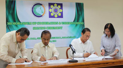 Climate Change Commissioner Heherson Alvarez (second from left) and Department of Energy (DOE) Usec. Raul Aguilos (second from right) sign the first MOU between the two agencies to promote renewable energy. CCC Asst. Sec. Rex Lores (leftmost) and DOE Director Carmencita Bariso (rightmost) acted as witnesses.