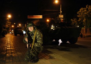 A member of the Ukrainian national guard takes position outside the parliament during military exercises in the center of Kiev early on Friday. Ukraine’s armed forces are on “full combat alert” against a possible Russian invasion, Kiev said, as authorities admitted they were “helpless” to prevent pro-Kremlin insurgents tightening their grip on the increasingly chaotic east of the country. AFP PHOTO