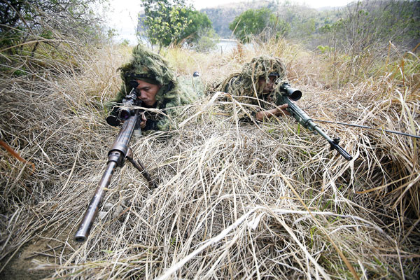 Snipers from the Philippine Marines try to blend into their surroundings during a live-fire training exercise at the Marine Base Camp in Ternate, Cavite, on Sunday. The exercise is part of Balikatan, the joint war drills of Philippine and American troops. PHOTO BY MIGUEL DE GUZMAN