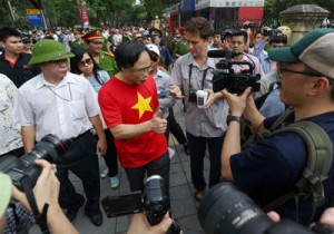 Anti-China protester Dao Minh Chau (center) speaks with reporters on a street near to the Chinese embassy in Hanoi on Sunday. A call for further anti-China protests appeared to have fizzled in the capital, with authorities deploying heavy security around the Chinese embassy and other suspected protest sites. AFP PHOTO