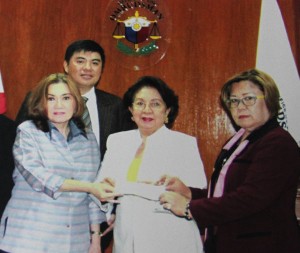 A handout photo from the Office of the Ombudsman shows Ruby Tuason (left) accompanied by her lawyer Dennis Manalo (back) giving a check to Ombudsman Conchita Carpio Morales (middle) and Justice Secretary Leila de Lima. The check for P40 million represents the amount she pocketed for herself from the pork barrel scam. In exchange for the return of the money, Tuason was granted state witness status by the Ombudsman, giving her immunity from suit arising from the scam.