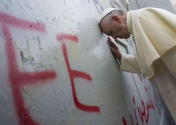 Pope Francis prays at Israel’s separation barrier on Sunday after making an unscheduled stop at the wall separating Israel and Palestine. The Pope, on a three-day Middle East tour, sought an end to the Israeli-Palestinian conflict and called on leaders to show courage to achieve peace based on a two-state solution. AFP PHOTO