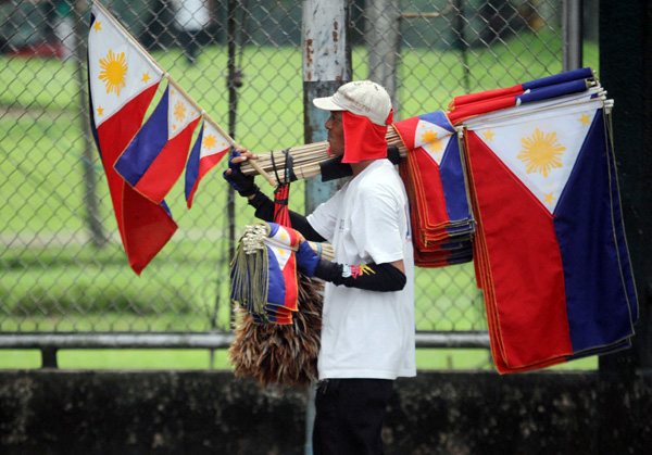 An assortment of Philippine flags is sold on North Avenue in Quezon City on Thursday. The vendor wants to cash in early on the celebration of Independence Day on June 12. Photo By Mike De Juan 