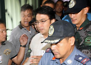 Surrounded by police escorts, Sen. Ramon “Bong” Revilla leaves the Sandigan- bayan after his arraignment on Thursday. Photo By Mike De Juan