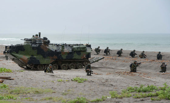 Philippine Marines take position next to a US amphibious assault vehicle (AAV) during a mock beach assault as part of Cooperation Afloat Readiness and Training (CARAT 2014) along the beach at a Philippine naval training base facing the South China Sea in San Antonio, Zambales, on Monday. AFP PHOTO 