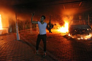 This file picture taken on September 11, 2012 shows an armed man waving his rifle as buildings and cars are engulfed in flames after being set on fire inside the US consulate compound in Benghazi. The US military captured a key suspect linked to the deadly 2012 attack on the consulate in Benghazi in a secret raid in Libya over the weekend, the Pentagon said on Wednesday. AFP PHOTO