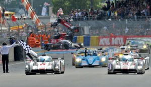 The Audi R18 e-tron quattro hybrid No. 2 car driven by Benoit Treluyer (right) crosses the finish line just ahead of the team’s No. 1 car of Tom Kristensen in Le Mans. AFP PHOTO