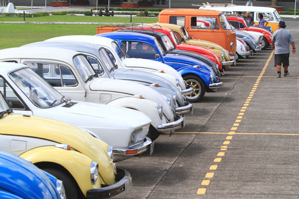 Enthusiasts walk past rows of Volkswagen vehicles at the parade grounds of Camp Aguinaldo in Quezon City on Sunday, World Volkswagen Day. PHOTO BY MIGUEL DE GUZMAN