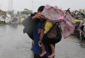 A flimsy umbrella provides no protection to a father and his daughter running to an evacuation shelter at the height of the typhoon early Wednesday. 