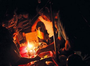 A man sells his wares by the light of a gas lamp in Quezon city. many areas in metro manila were still without electricity on thursday. Photo by Ruy Martinez