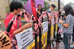 ■ Students tie peach ribbons on street balustrades at the University belt as they join the clamor to hold officials behind the implementation of the Disbursement Acceleration Program accountable for the illegal use of the funds. PHOTO BY RUY MARTIN