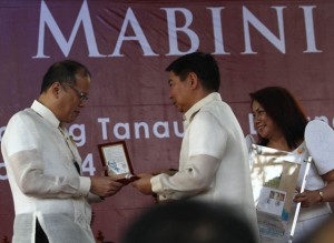 President Benigno Aquino 3rd receives a commemorative coin presented by Bangko Sentral ng Pilipinas (BSP) Governor Amando Tetangco Jr. during the commemoration of the 150th birth anniversary of Apolinario Mabini at the Apolinario Mabini Shrine in Barangay Talaga, Tanauan City on Wednesday. MALACAÑANG PHOTO