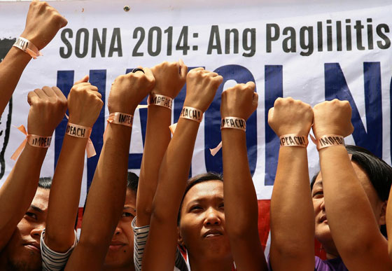 Members of a militant group raise their fists to show off peach ribbons during a press conference in Sta. Mesa, Manila on Saturday. The group joined the call for government accountability in disbursing public funds.photo By ruy L. mArtIneZ 