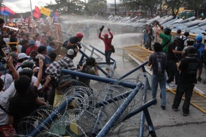  Drenched protesters try to smash through the barricade along Commonwealth Avenue as they press towards Batasang Pambansa, where the President was delivering his SONA on Monday. PHOTO BY RUY MARTINEZ 