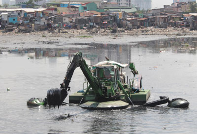 A water backhoe digs up soil and trash from a creek along Pasong Tamo in Pasay City (Metro Manila) on Wednesday. The government is cleaning up creeks in the region to avoid flooding during the rainy season.PHOTO by Ruy L. mARTinEZ 