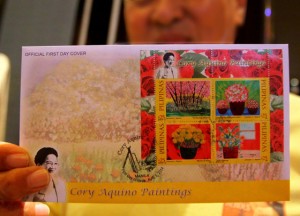 A PhilPost personnel shows off scented stamps featuring the paintings of democracy icon and former President Cory Aquino on Tuesday. The stamps would be the first in the Philippines to have a  rose scent. Photo by Edwin Muli